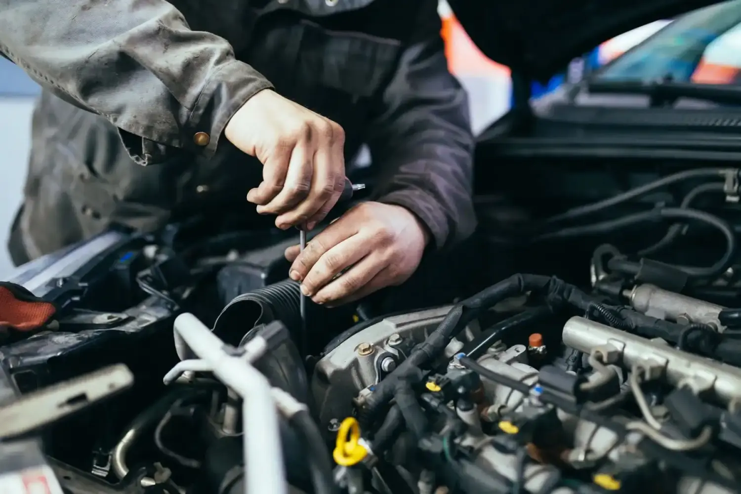 Männlicher Mechaniker füllt Autoöl im Servicecenter nach